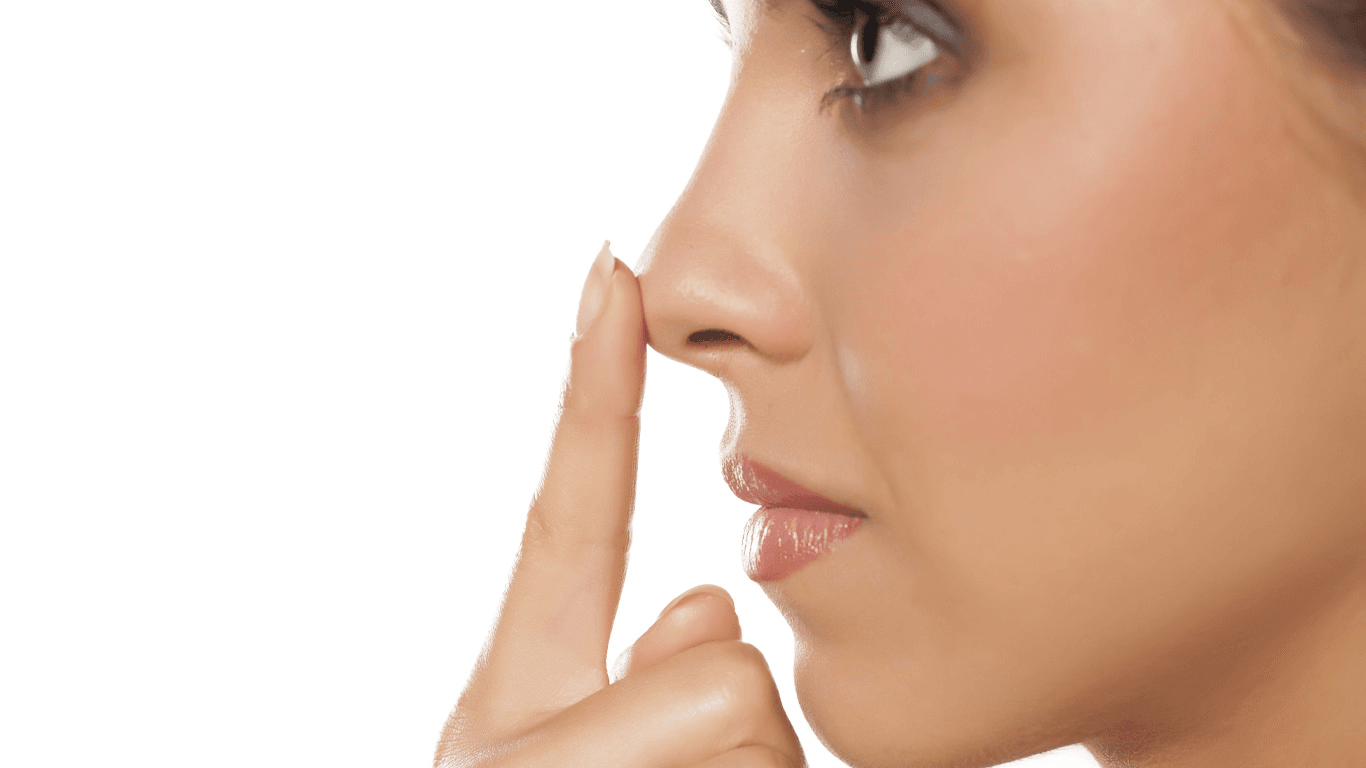 A woman is shown applying cream to her face, focusing on her nose and mouth area. The image highlights a skincare routine with a close-up view of her face and hand.
