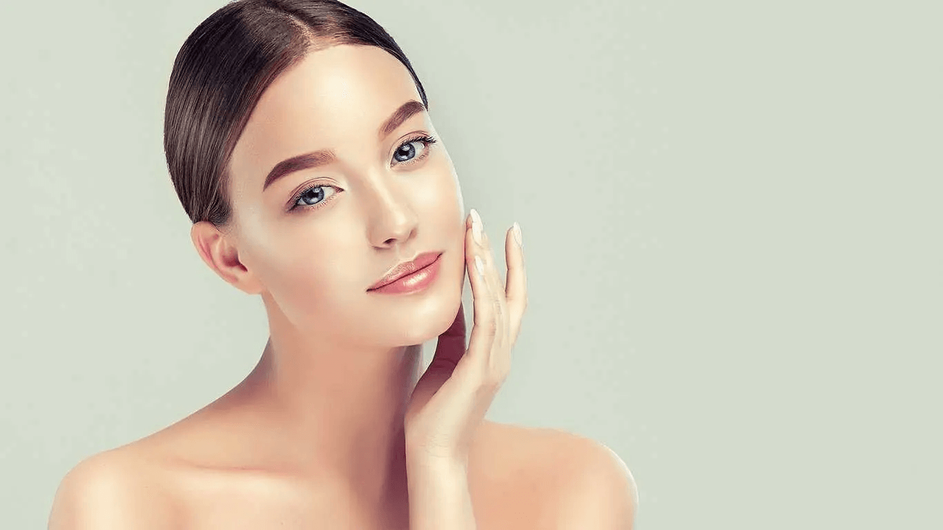 A young woman with smooth skin gently touching her face, showcasing natural beauty and clear complexion.