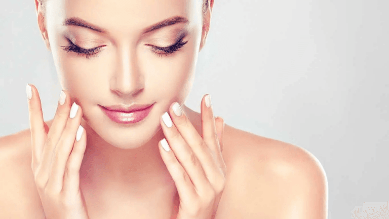 A woman with closed eyes gently touching her face, showcasing smooth and clear skin.