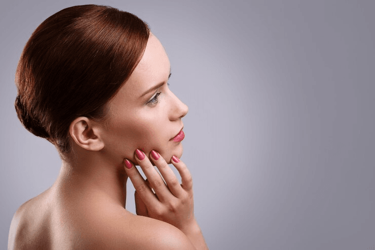 A woman with her hand on her chin, appearing thoughtful or contemplative.