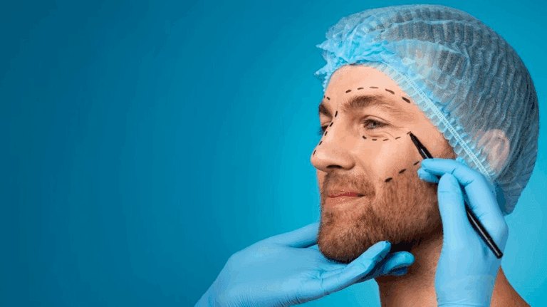 A surgeon, wearing a blue cap and gloves, marks a patient's face with a marker before a cosmetic procedure. The patient has a beard and is facing to the side while the surgeon points to his face with a pen.