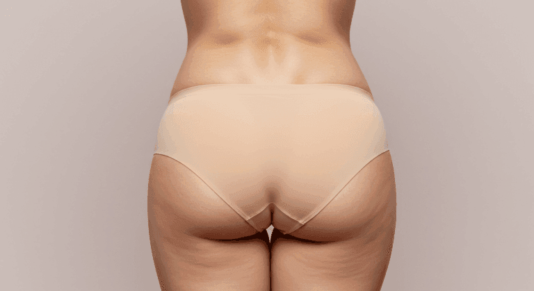 A close-up view of a person's lower torso and buttocks from behind, emphasizing the shape and contours of the buttocks and lower back.