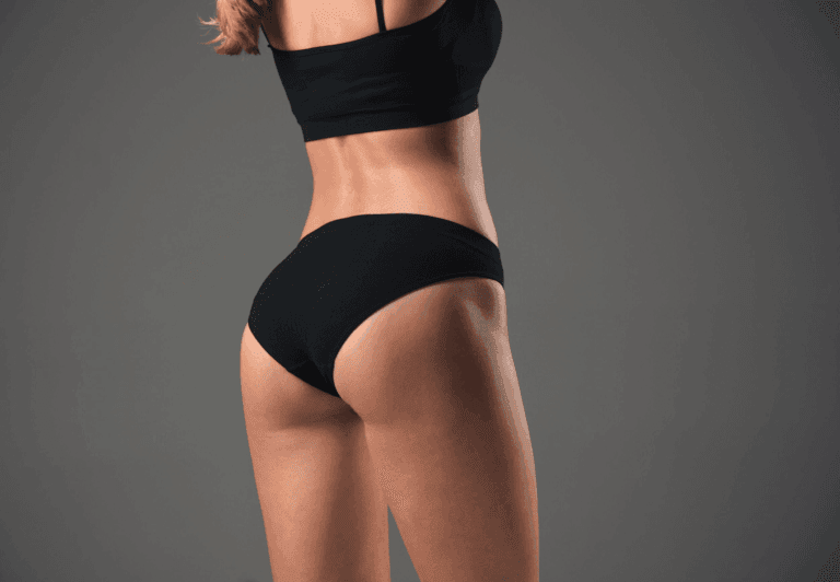 A person wearing black athletic clothing, including a sports bra and shorts, is shown from the back. The focus is on their toned back muscles and legs, with a dark, textured background.