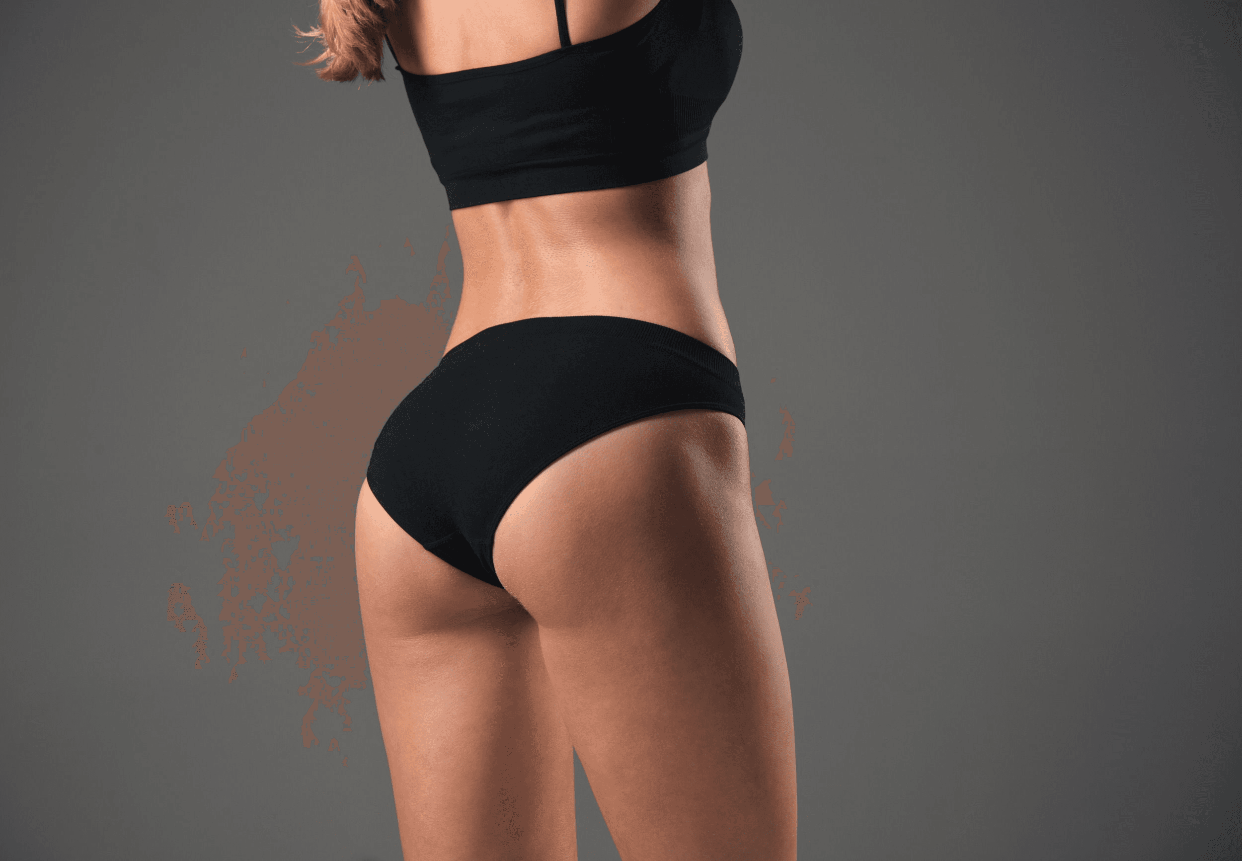 A person wearing black athletic clothing, including a sports bra and shorts, is shown from the back. The focus is on their toned back muscles and legs, with a dark, textured background.