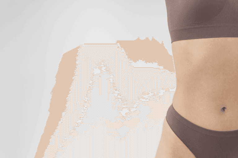 A person's torso wearing a brown sports bra and matching shorts, standing against a white background.