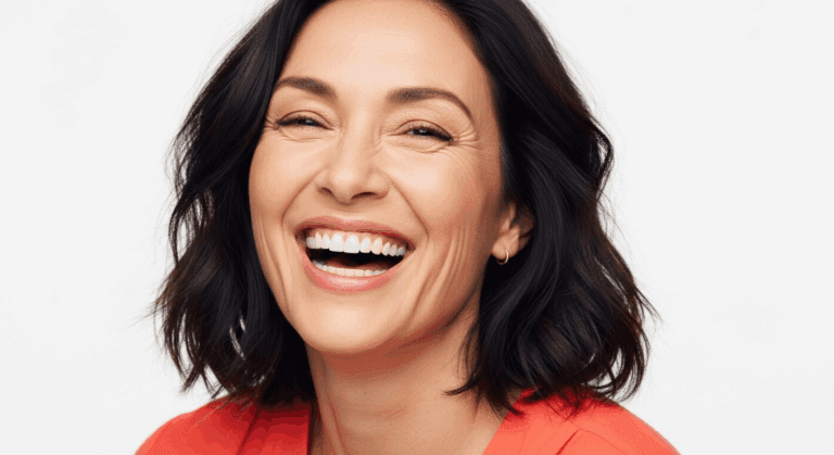 A smiling woman with short dark hair wearing a red top.