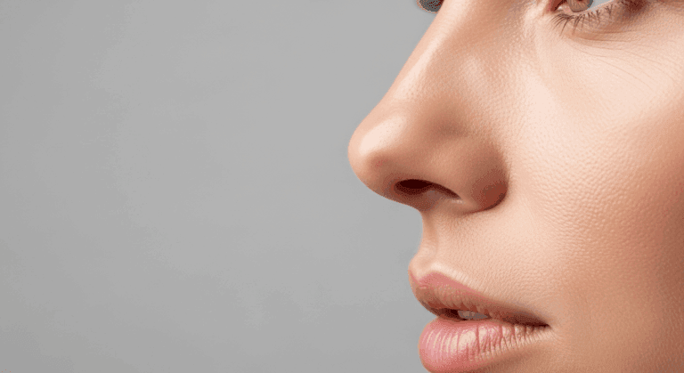 A close-up side profile of a person's face, focusing on the nose and lips against a plain background.